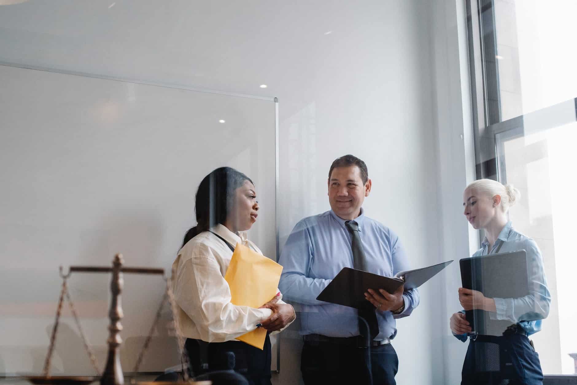 Professional diverse colleagues talking about work in modern office