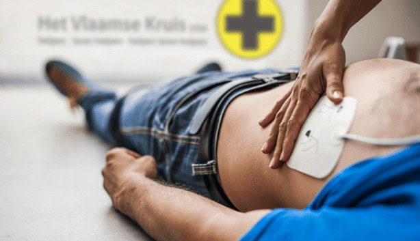 someone laying on floor, with a press pad on his side with a hand on the top of it